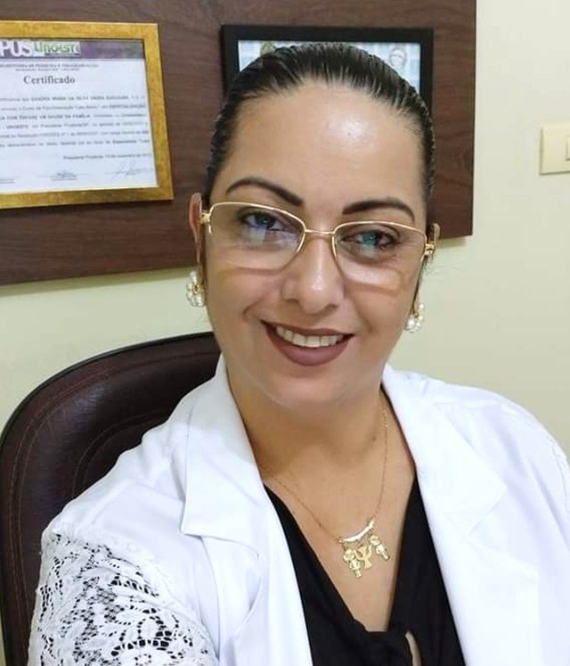 Sandra Suguiura Mota em seu consultório em Pereira Barreto, com certificados de formação na parede ao fundo